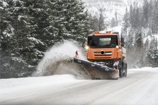 Snow plow clearing a wintry road